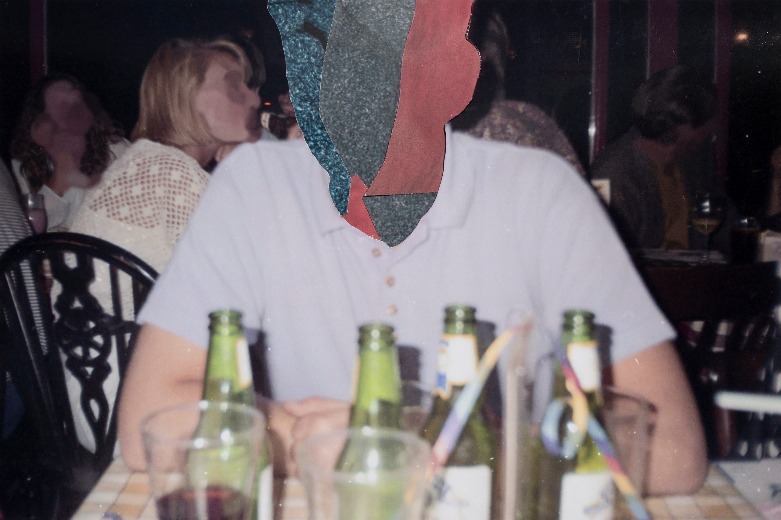 A photograph of a person sat at a table covered in beer bottles and glasses. Their face has been obscured with a collage of various colours and shapes.